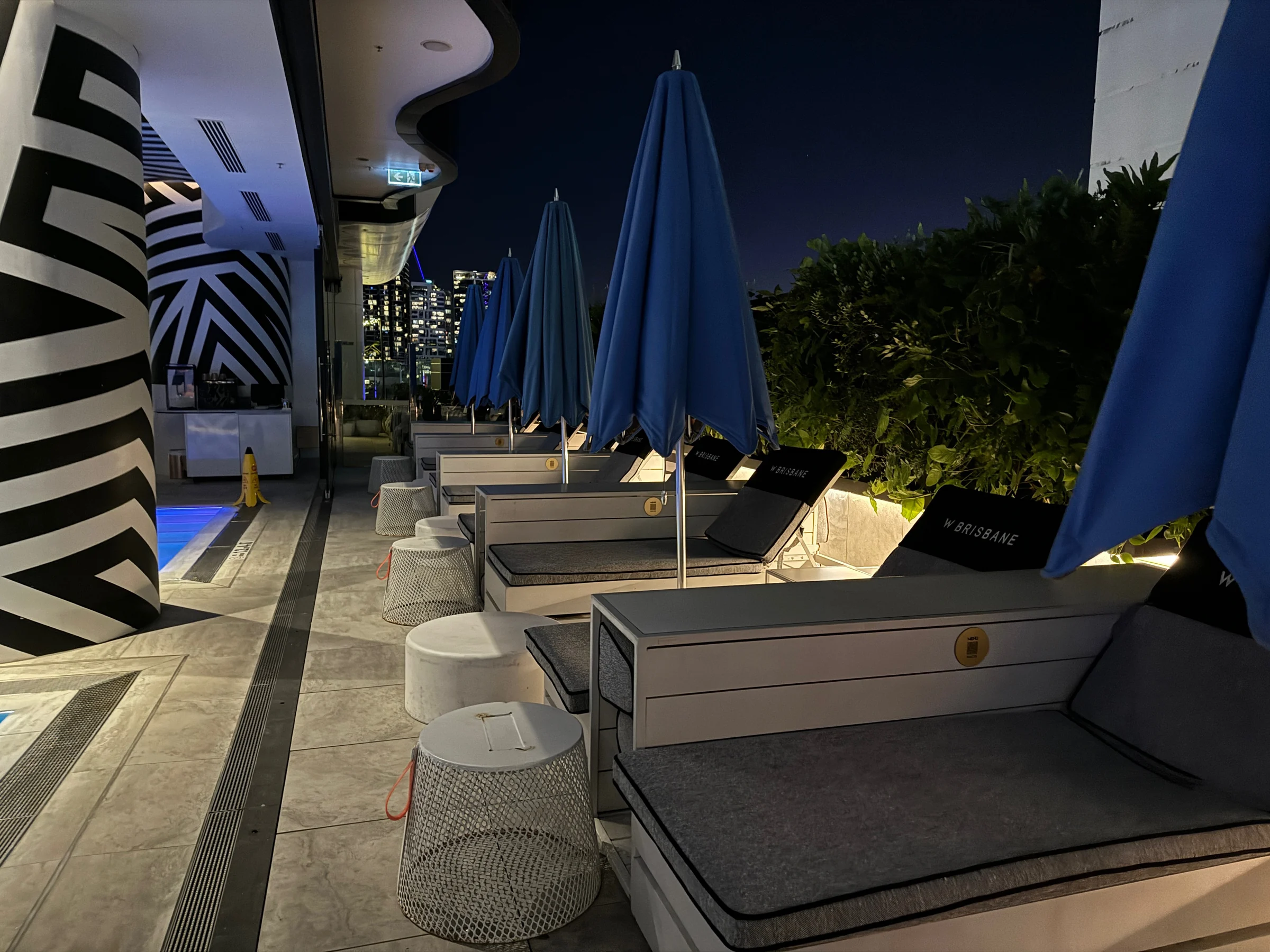 Chairs along the poolside at night.