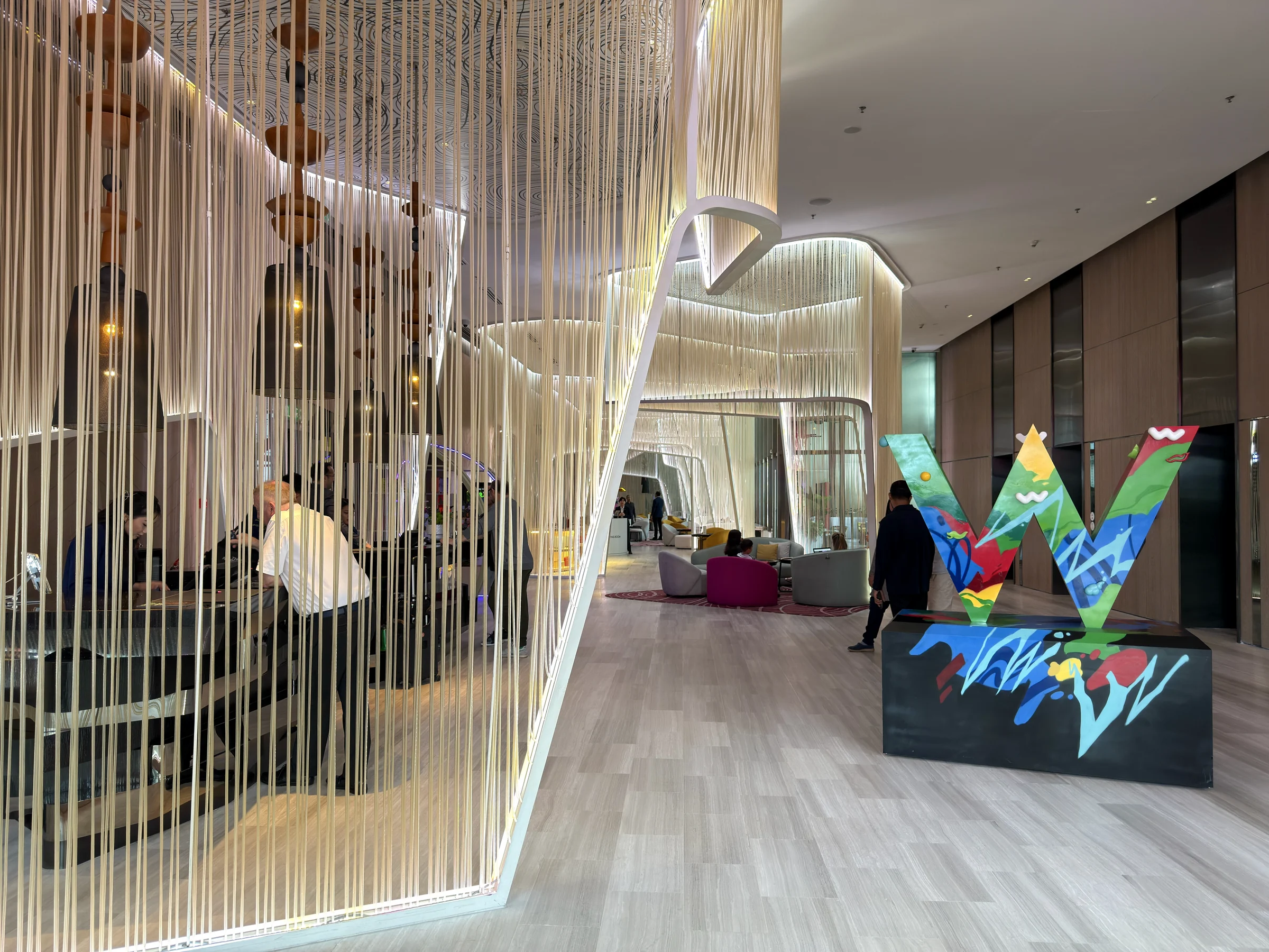 A W sculpture and white curves in the lobby.