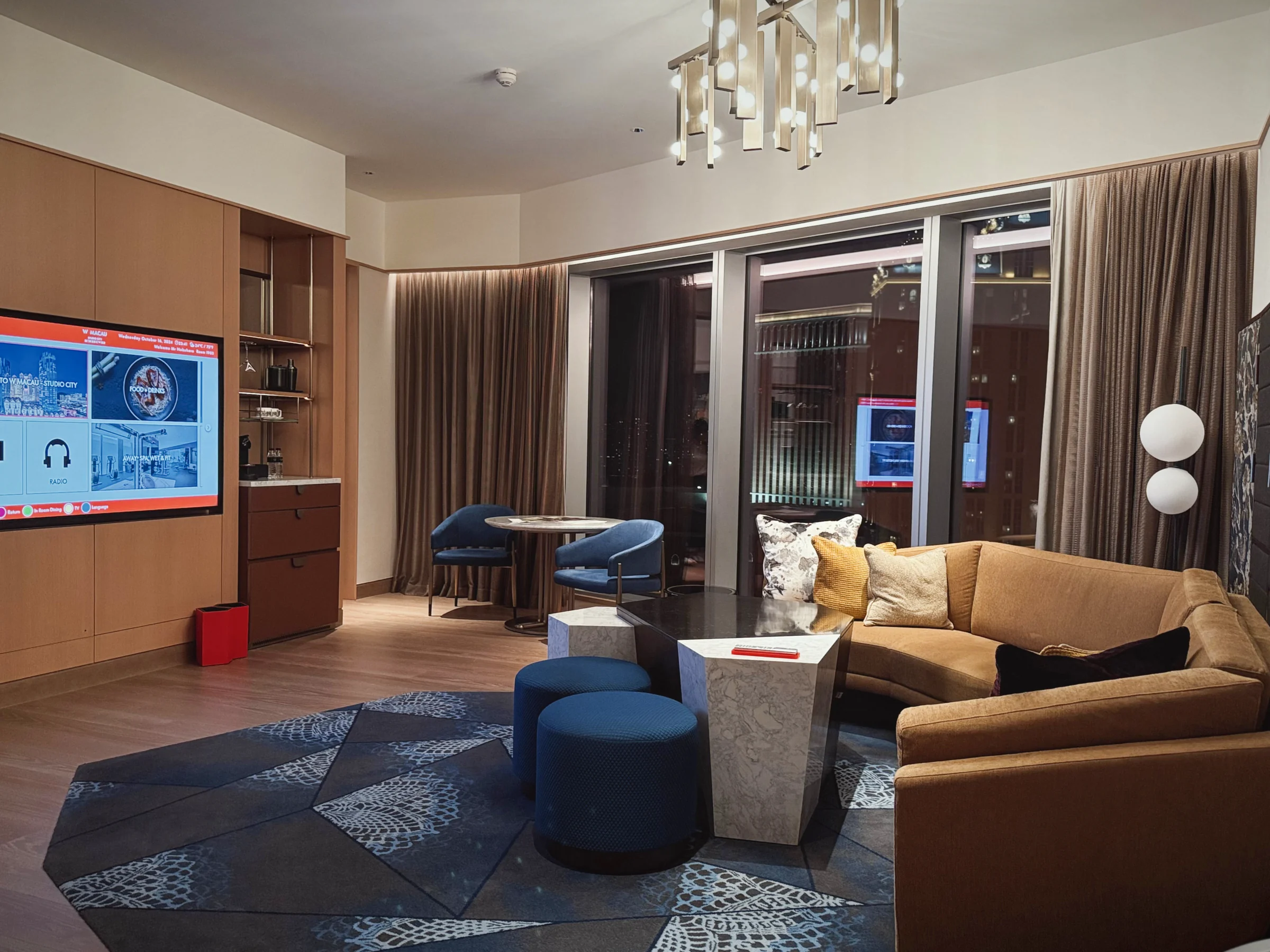 W Macau's Marvelous Suite living room, with a yellow sofa and blue stools