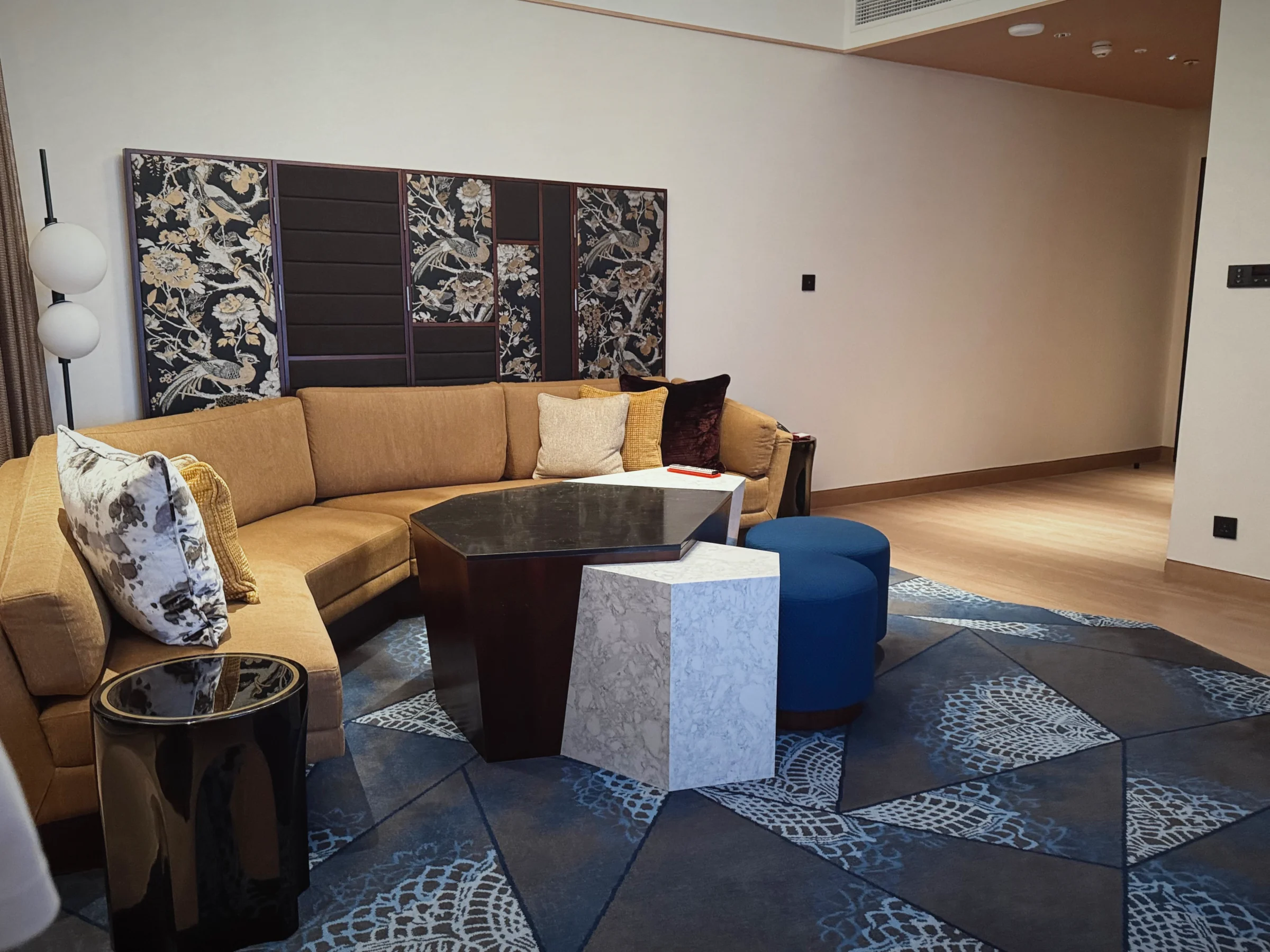 An L-shaped sofa and blue stools