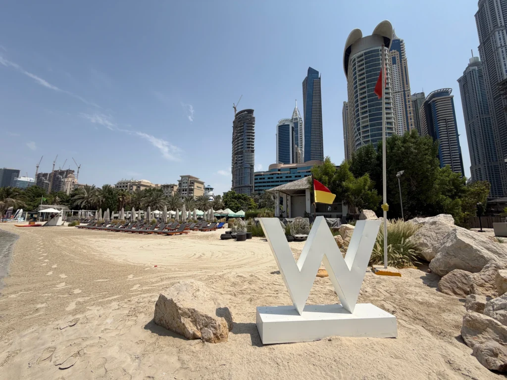 A white W on the beach at W Mina Seyahi, with Dubai’s towers beyond