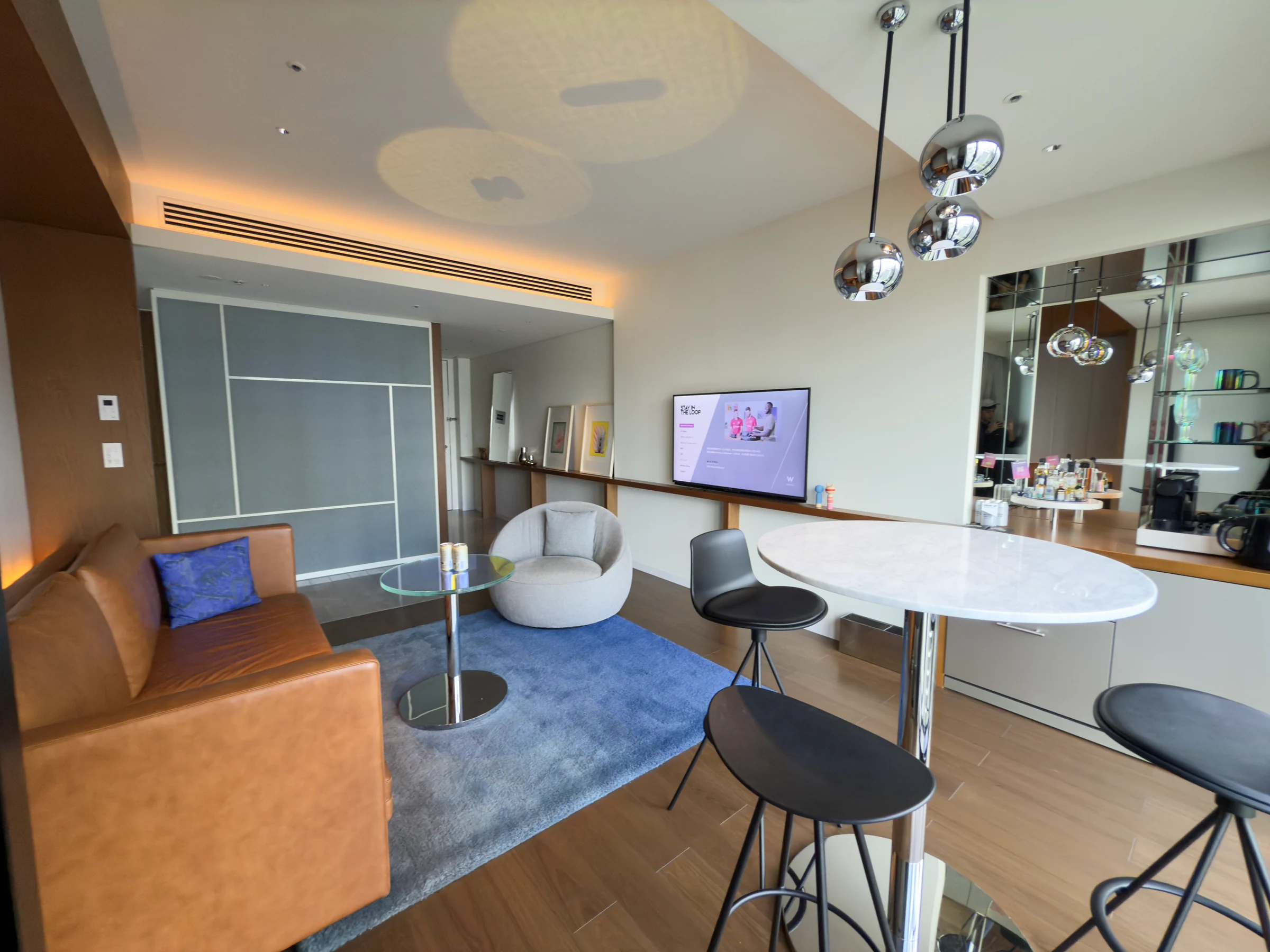 W Osaka's Marvelous Suite, with an orange sofa, round table and windows facing Midosuji