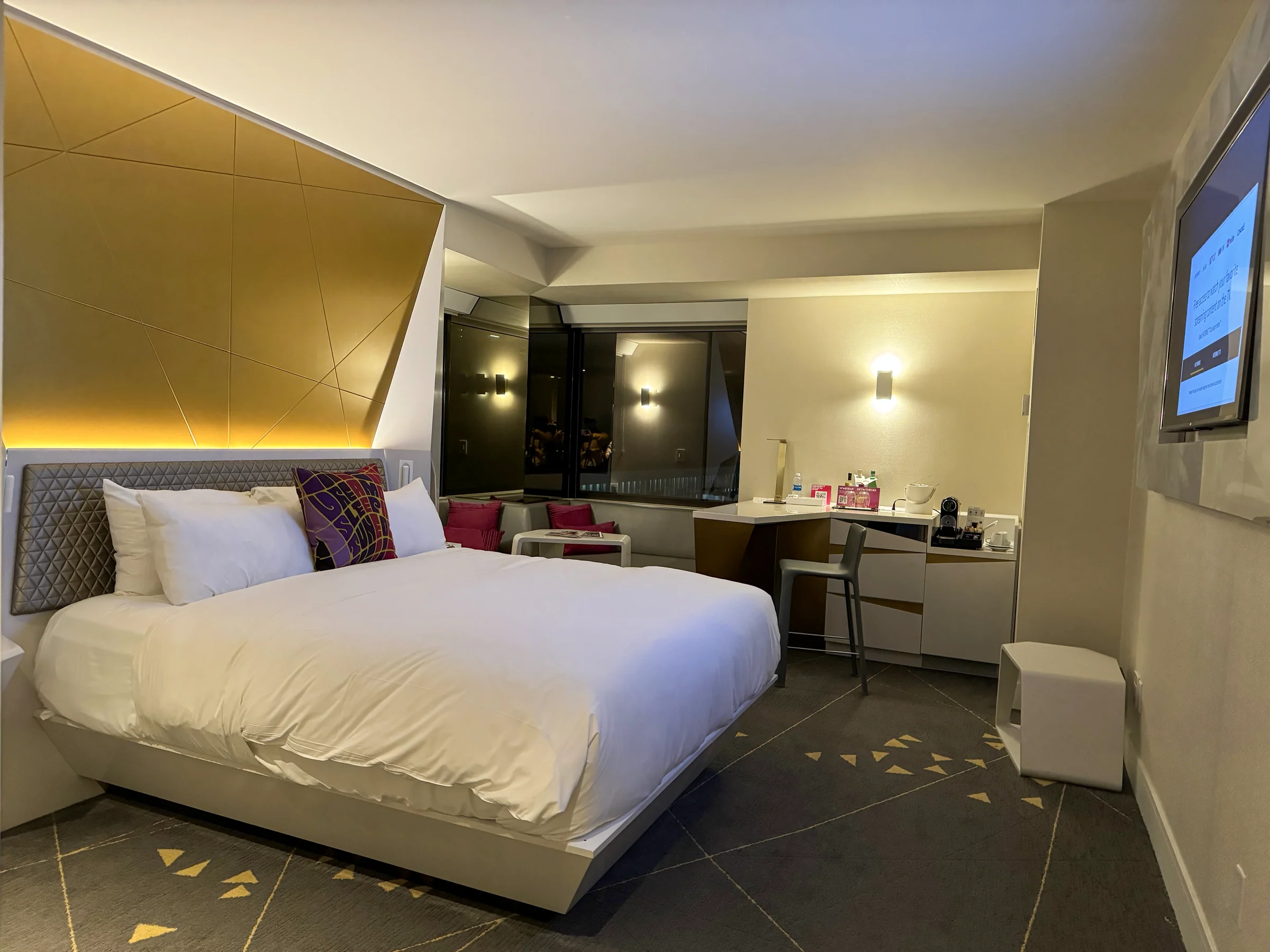 The Studio Suite with gold walls and white bedding.