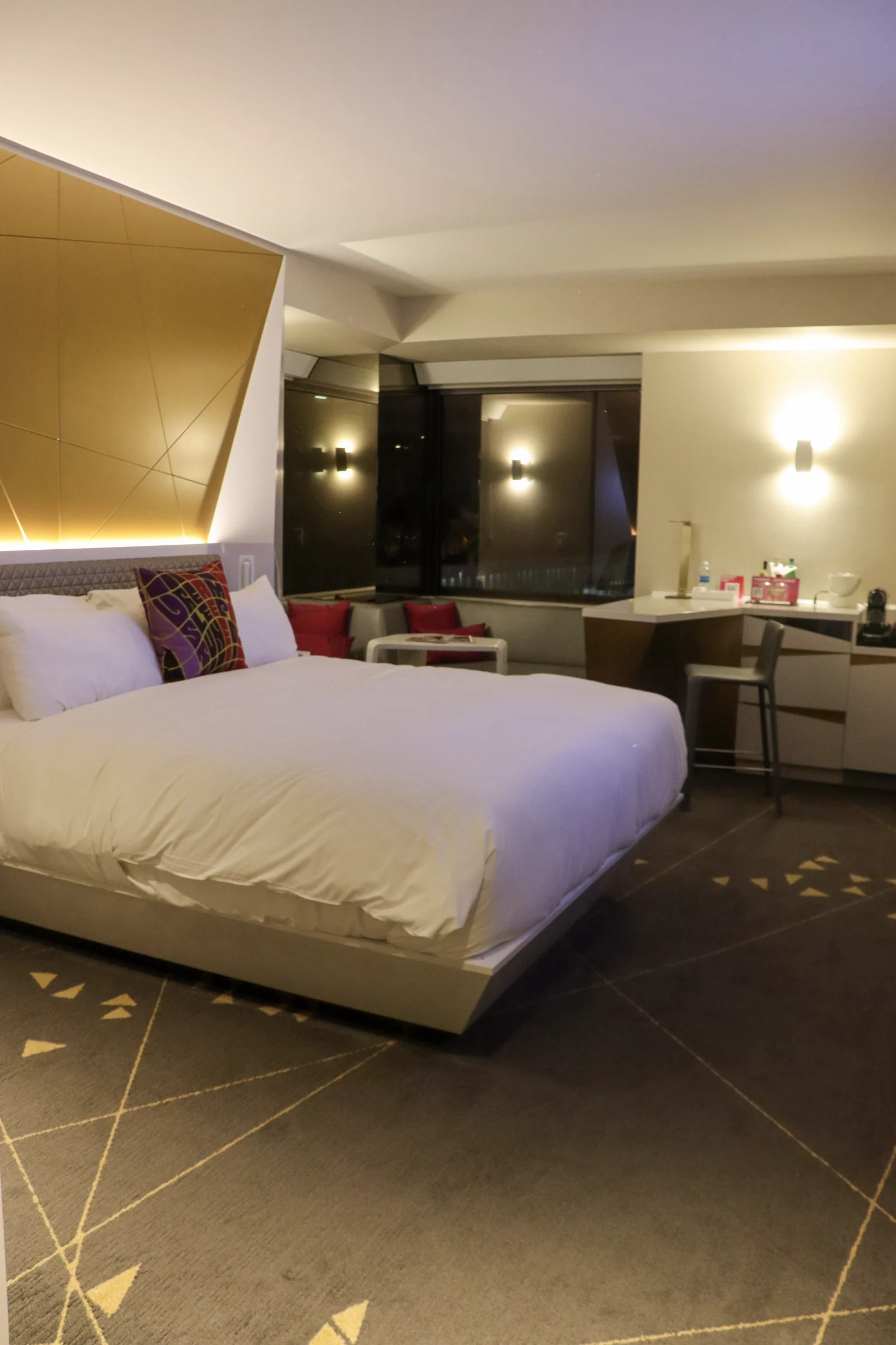The room stretching from the bed to the desk beyond.