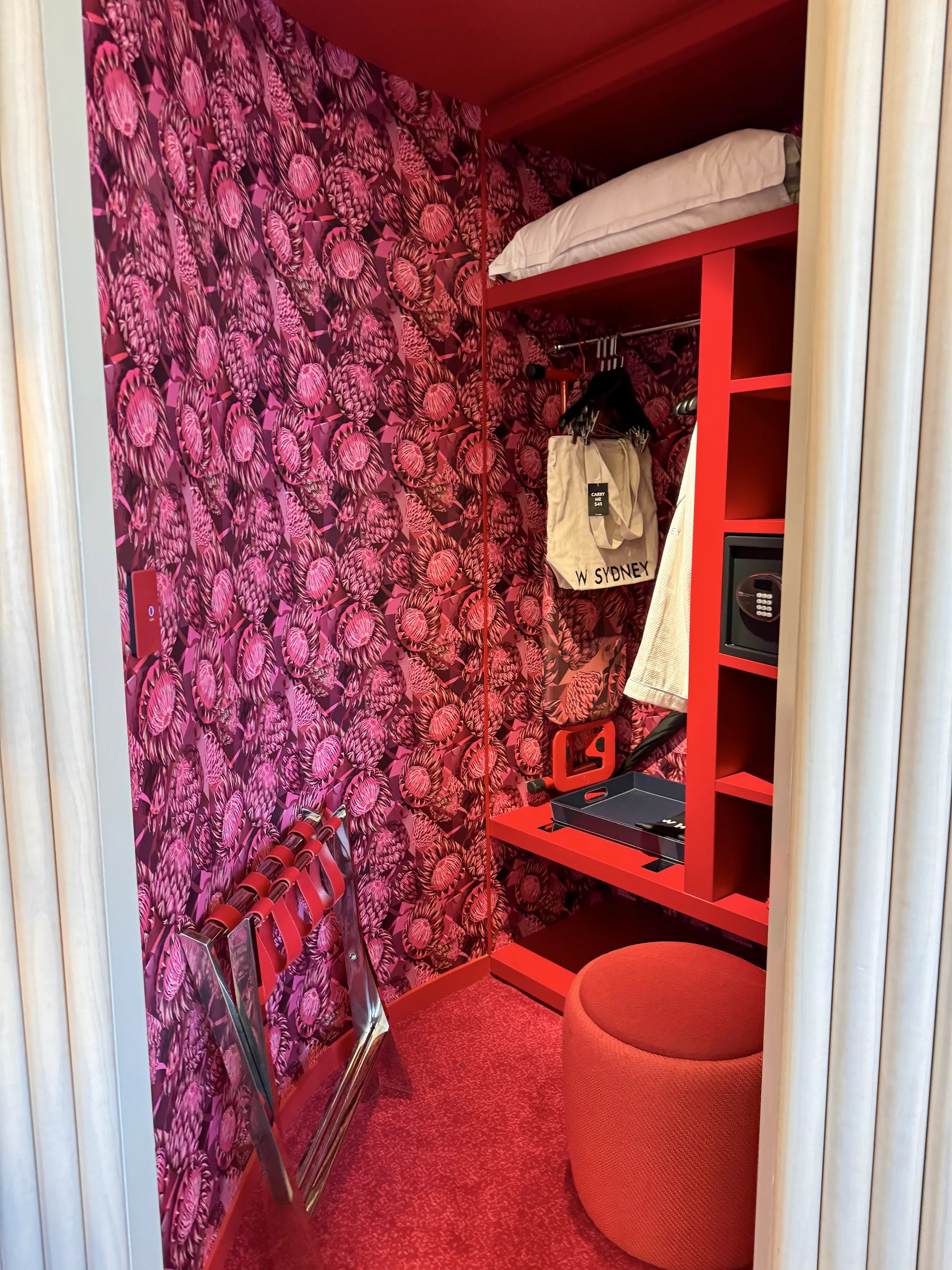 A wardrobe with red floral patterns behind the doors.