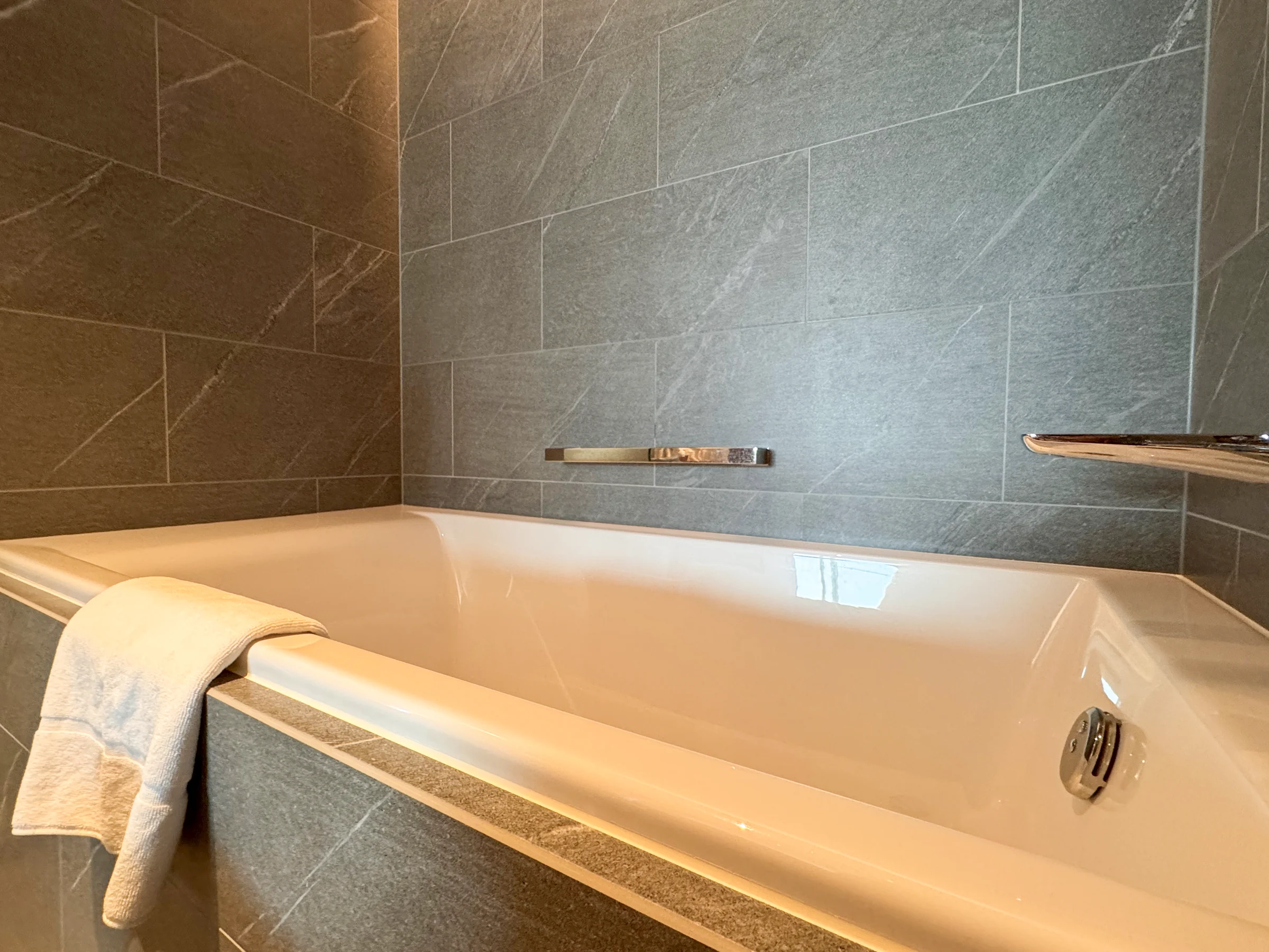 A deep bathtub with a push-button tap