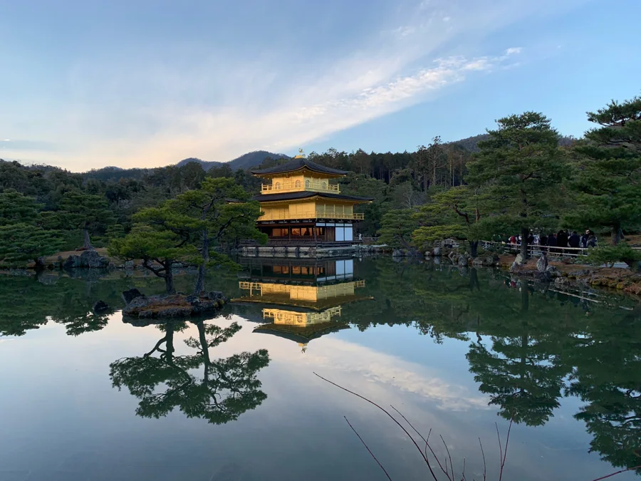鏡のような池に金閣寺と夕空が映り込む風景